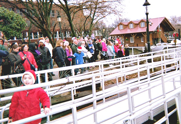 Spectators watching a Christmas show and taking pictures with mobile phones.