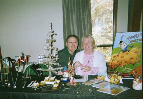 Woman displaying her home made jewelry and books at a local craft show.