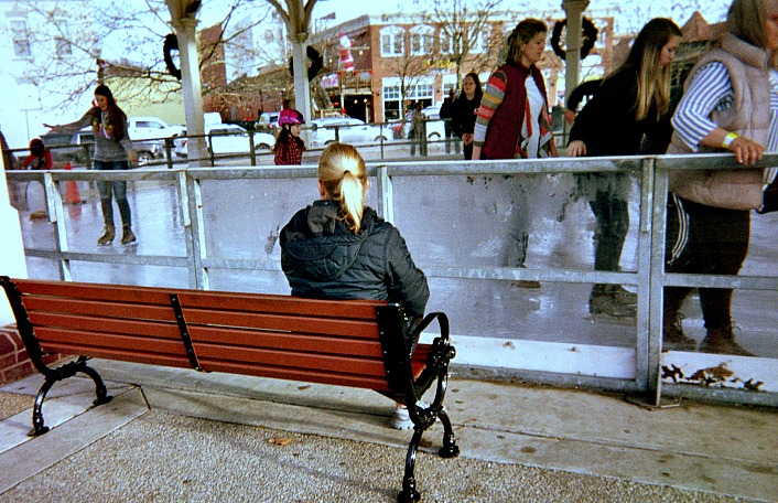 Teens skating at an ice rink.