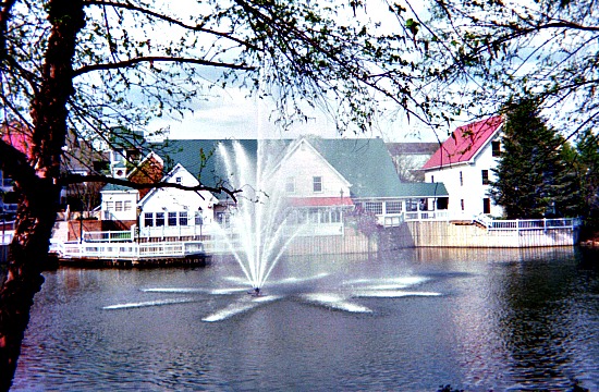 Water fountain spouting from a pond in front of a restaurant in Tackett's Mill.